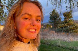 Jente som smiler mot kamera - Klikk for stort bilete